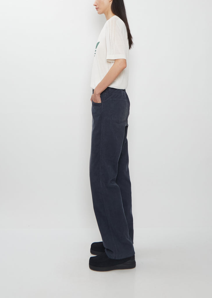 Side view of a person wearing the Visvim Fluxus Boot Cut Pant in navy.
