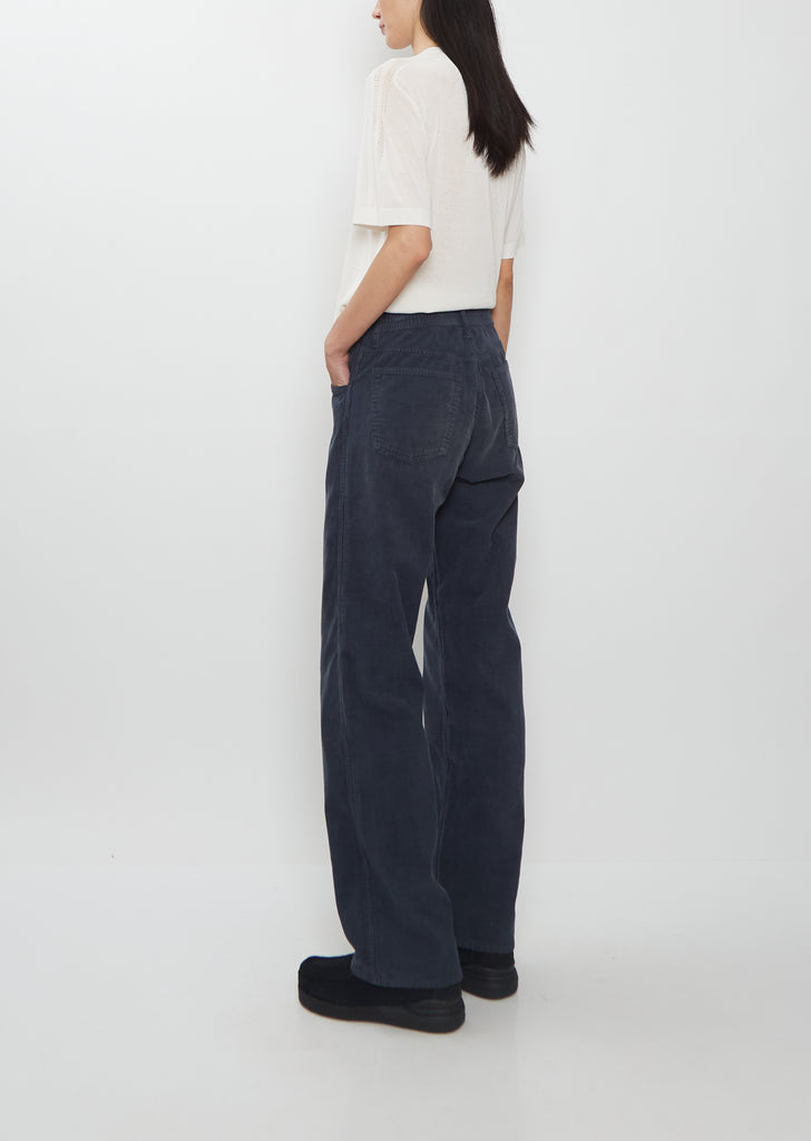 Rear view of a model wearing Visvim navy Fluxus Boot Cut Pants with straight legs.