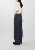 Rear view of a model wearing Visvim navy Fluxus Boot Cut Pants with straight legs.