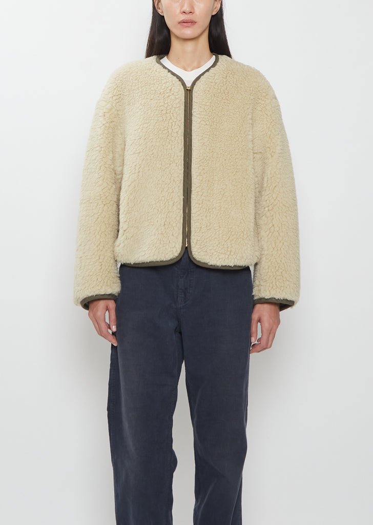 Front view of a model wearing the Visvim Liner Down Jacket in ivory with a relaxed, boxy fit and cropped length.