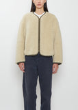 Front view of a model wearing the Visvim Liner Down Jacket in ivory with a relaxed, boxy fit and cropped length.