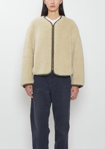 Front view of a model wearing the Visvim Liner Down Jacket in ivory with a relaxed, boxy fit and cropped length.