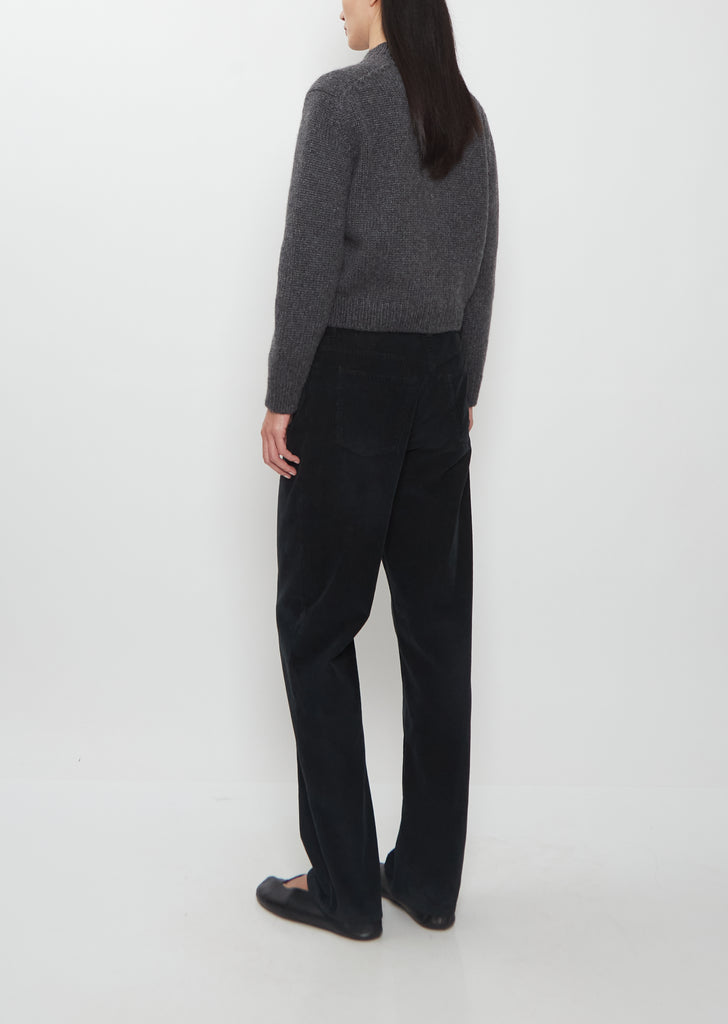 Rear view of a model wearing The Row Duvan Cotton Corduroy Pants in faded black.