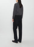 Rear view of a model wearing The Row Duvan Cotton Corduroy Pants in faded black.