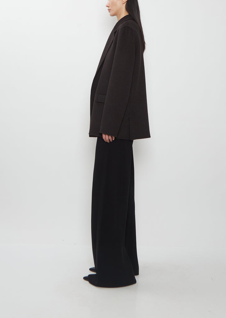 Side profile of The Row Cinna Cashmere Jacket in dark brown with matching wide-leg trousers.