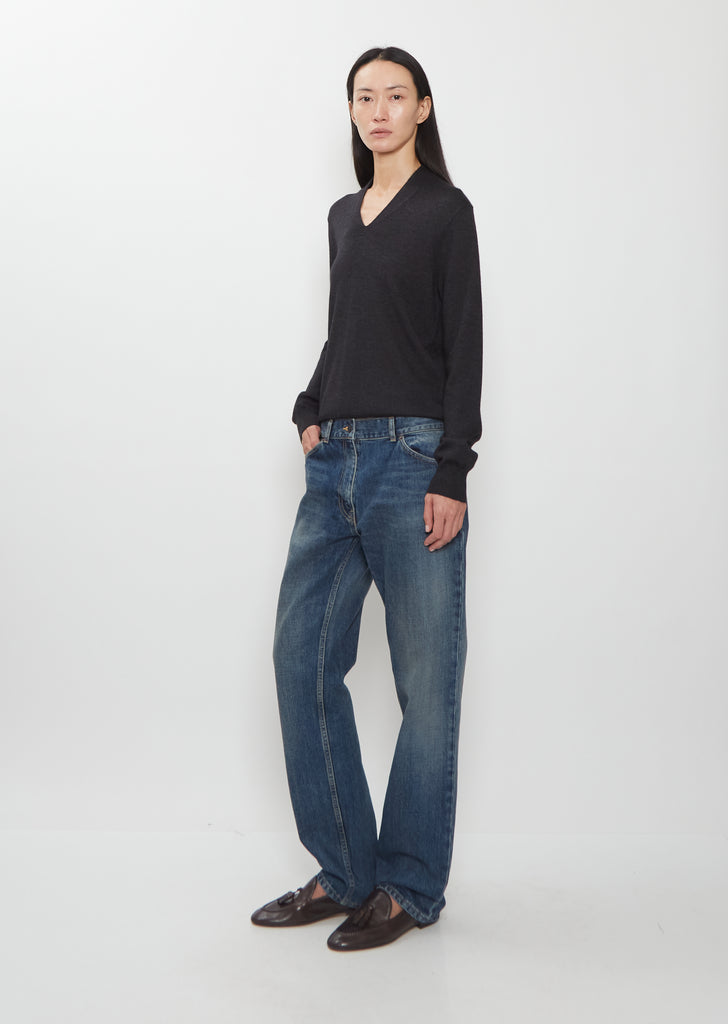 Full body shot of a model wearing The Row Dinni Cotton Jean in medium indigo.