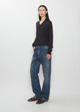 Full body shot of a model wearing The Row Dinni Cotton Jean in medium indigo.