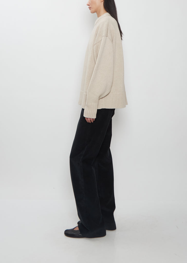 Side view of The Row Ophelia Wool Cashmere Top in sand beige, showing the relaxed fit and bell sleeves.