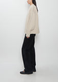 Side view of The Row Ophelia Wool Cashmere Top in sand beige, showing the relaxed fit and bell sleeves.