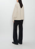 Back view of the Ophelia Wool Cashmere Top in sand beige, showing its relaxed oversized fit.