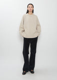 Full view of the Ophelia Wool Cashmere Top in sand beige with black trousers.