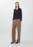 A full-length view of the Adler Cotton Corduroy Pant by The Row in faded sepia, paired with a dark grey sweater.