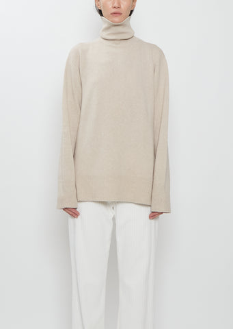 Front view of The Row Stepny Wool Cashmere Top in sand beige with a turtleneck.