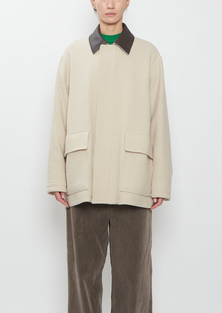 Front view of the Auralee Homespun Tweed Zip Blouson in ivory beige on a model.