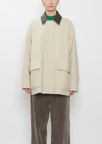 Front view of the Auralee Homespun Tweed Zip Blouson in ivory beige on a model.