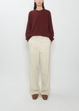 Front view of a model wearing Auralee Wool Fulling Flannel Drawstring Pants in top ivory.