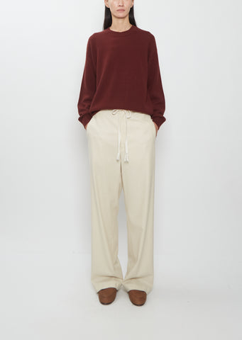 Front view of a model wearing Auralee Wool Fulling Flannel Drawstring Pants in top ivory.