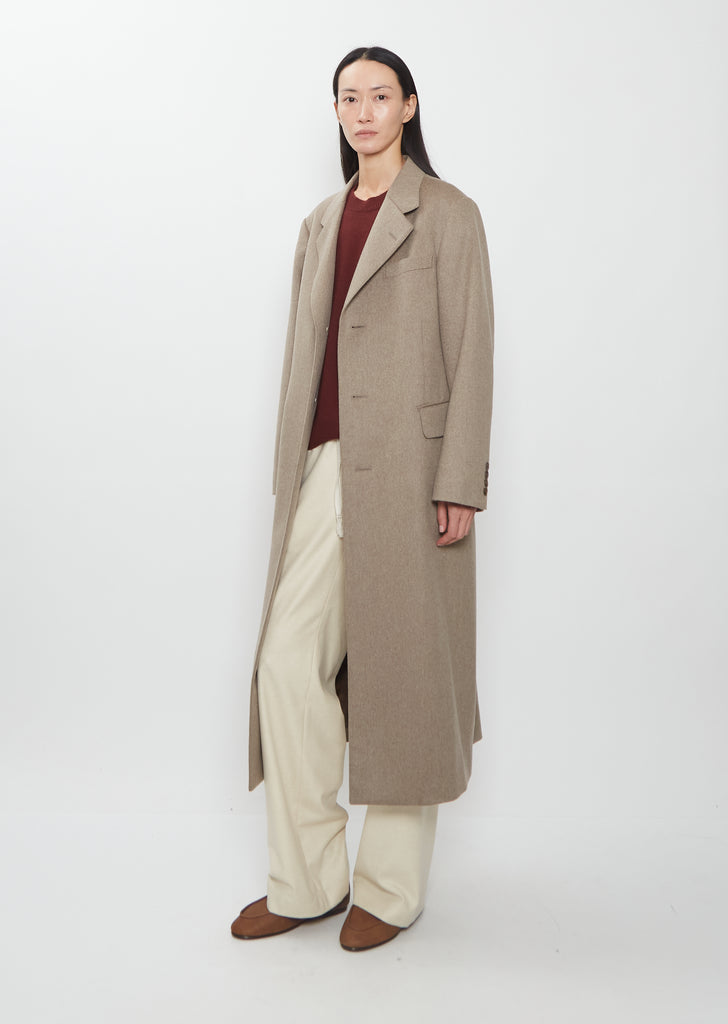 A model wearing the Auralee cashmere moleskin long coat.