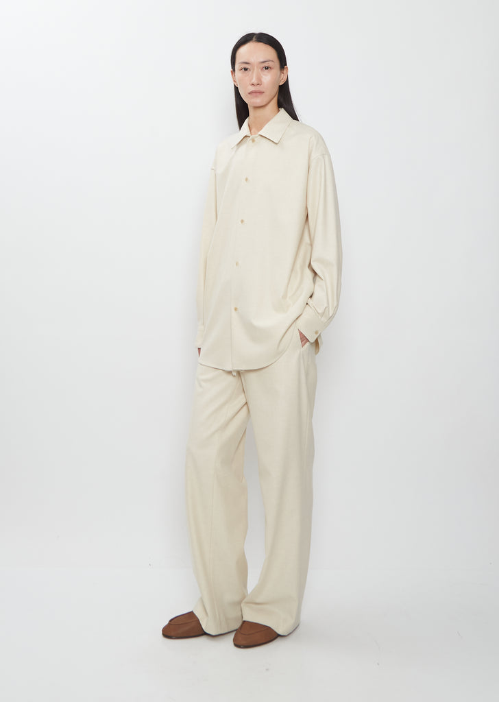 Full-length view of the Auralee Wool Fulling Flannel Shirt in Top Ivory worn with matching trousers.