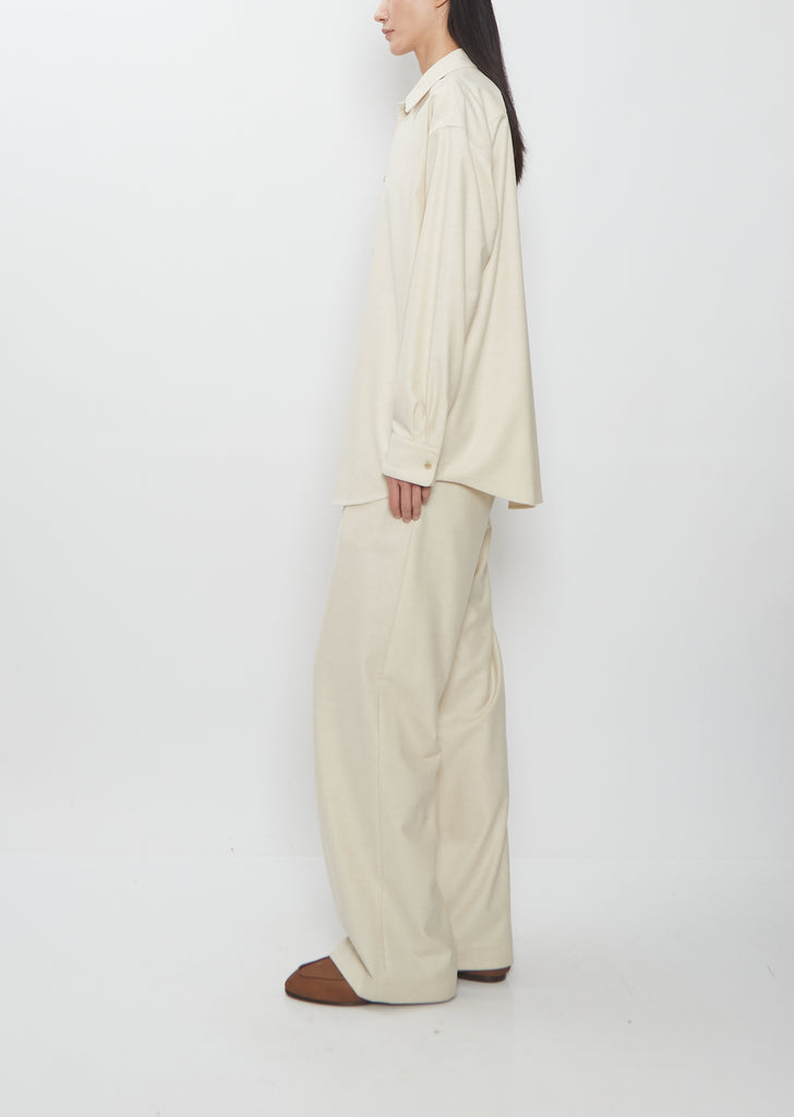 Side view of Auralee Wool Fulling Flannel Shirt in Top Ivory paired with matching trousers.