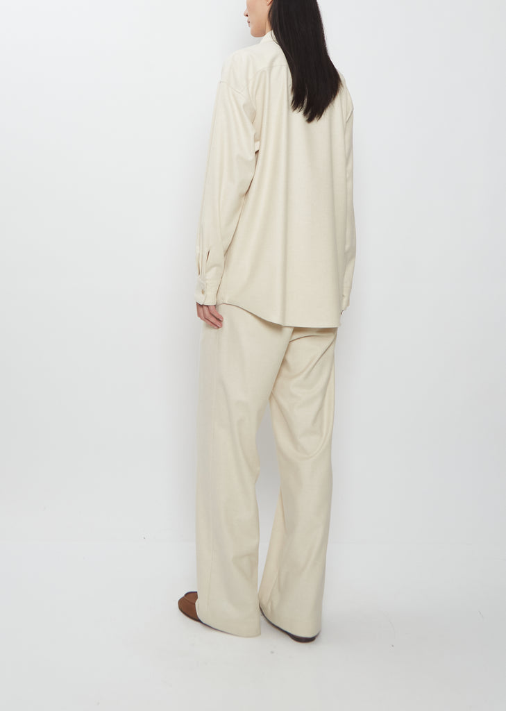 A woman seen from behind wearing the Auralee Wool Fulling Flannel Shirt and matching pants in Top Ivory.