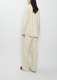A woman seen from behind wearing the Auralee Wool Fulling Flannel Shirt and matching pants in Top Ivory.