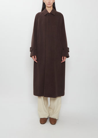 A person wearing a dark brown Super Fine Wool Mosser Soutien Collar Coat, light trousers, and brown shoes.